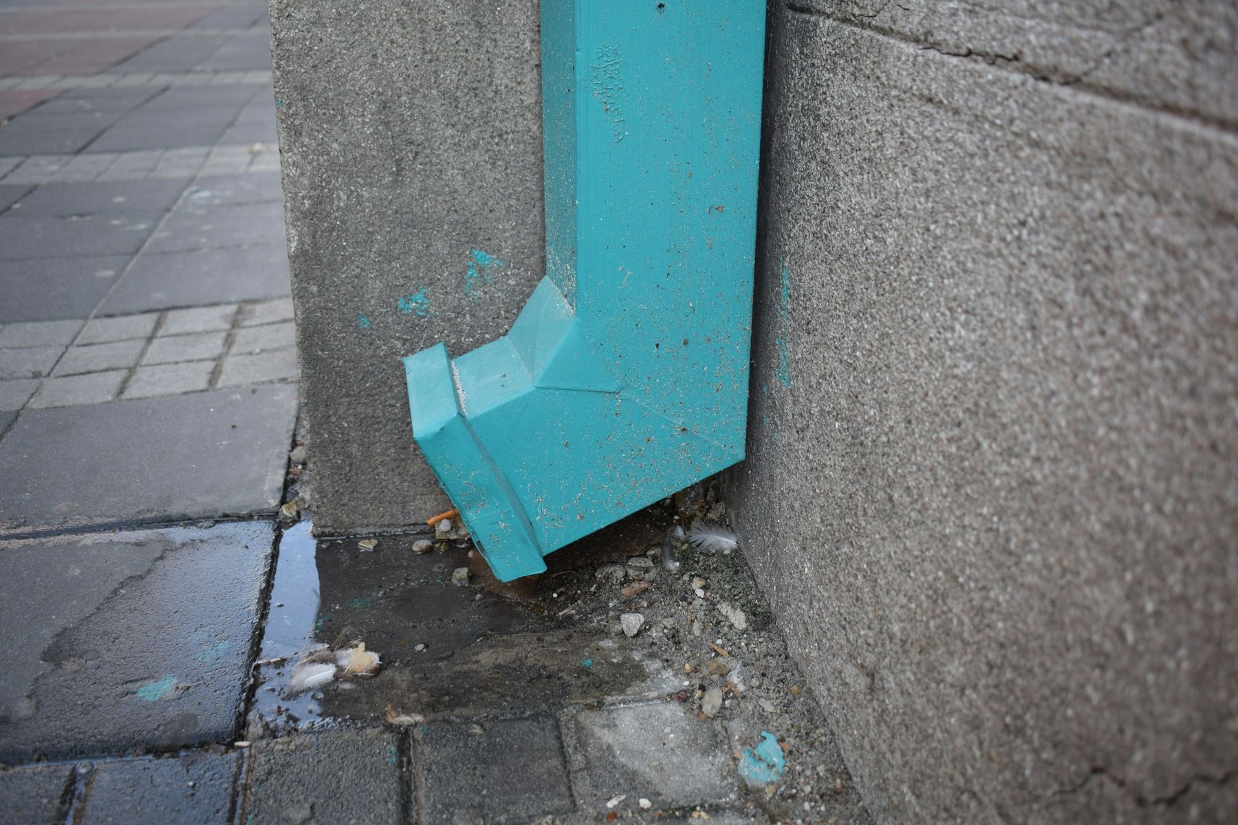 A downspout draining at the base of a wall