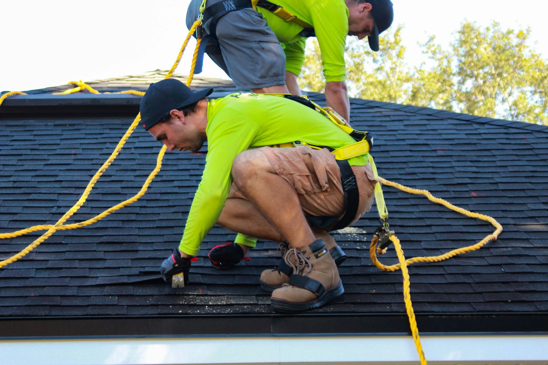 Roofers working on a shingle roof